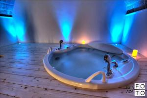 モノーポリにあるSuite Stone Luxuryの青い照明付きの客室内のバスタブ