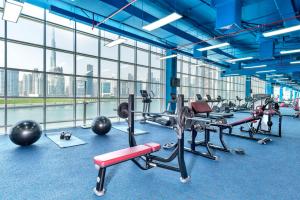 a gym with cardio equipment in a large room with windows at Canal Central Hotel in Dubai