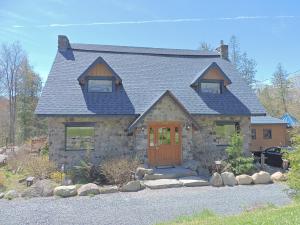 a stone house with a blue roof at Auberge Spa & Beaux Reves in Sainte-Adèle