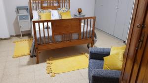 a room with a crib with yellow pillows and a couch at Vivienda Vacacional La Aldea de San Nicolas in La Aldea de San Nicolas