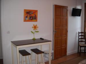 una habitación con una mesa y dos taburetes y una puerta en Hôtel du Commerce, en Millau