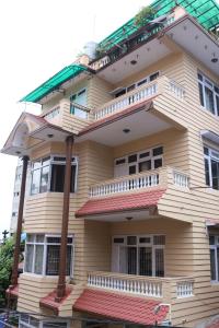 un gran edificio de madera con balcones blancos. en Kathmandu Peace Guesthouse en Katmandú