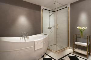 a bathroom with a tub and a glass shower at Rixos Pera Istanbul in Istanbul