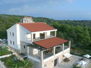 une vue aérienne sur une maison avec un toit rouge dans l'établissement Apartments Kaić, à Rogač