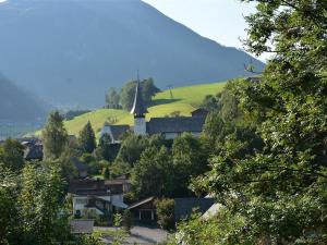 a small village with a church on a hill at Apartment Hübeli - Arm by Interhome in Zweisimmen