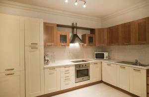 eine Küche mit weißen Geräten und Holzschränken in der Unterkunft BV7 - Bridge View Apartment in St Julian's