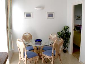 a dining room with a glass table and chairs at Apartment Club Sevilla I by Interhome in Casas Devesa