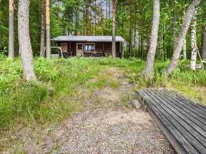 a small cabin in the middle of a forest at Holiday Home Mäntyranta by Interhome in Harjula