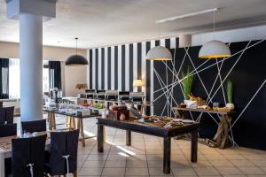 a restaurant with tables and chairs in a room at Skopelos Holidays Hotel & Spa in Skopelos Town +37 photos