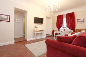uma sala de estar com um sofá vermelho e uma mesa em Daplace - Gaia Apartment em Roma