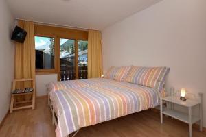 um pequeno quarto com uma cama e uma janela em Haus Bor em Zermatt