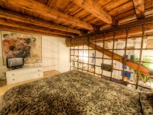 ヴェローナにあるCasa Archi - Vista sul Fiumeの木製の天井の客室で、ベッドルーム1室(大型ベッド1台付)