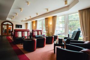 a waiting room with chairs and tables and windows at HK Hotel Düsseldorf City in Düsseldorf