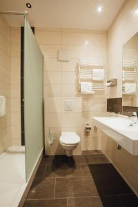 ein Bad mit einem WC, einem Waschbecken und einer Dusche in der Unterkunft HK Hotel Düsseldorf City in Düsseldorf