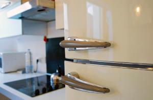 una cocina con asas de acero inoxidable en una nevera en BM1 - Blue Marine Apartment, en San Julián