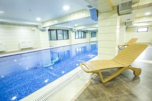 a swimming pool with a chair in front of it at Emerald Hotel Baku in Baku