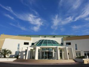 a white building with a glass roof and stairs at Hotel Maregolf in Caorle