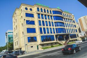 um grande edifício com janelas azuis numa rua da cidade em Emerald Hotel Baku em Baku