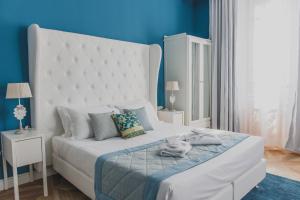 a bedroom with a white bed with a blue wall at B&B La Residenza di Michelangelo in Florence