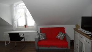 a red chair in a room with a window at Nowy Apartament w Centrum Włodawy in Włodawa