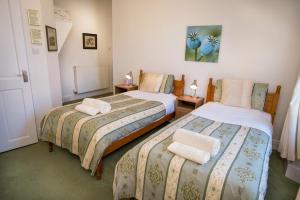 a bedroom with two beds with towels on them at Somerset House B&B in Grange Over Sands