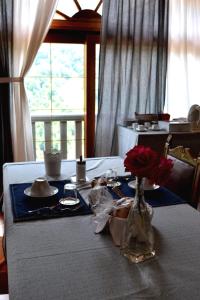 una mesa con un jarrón de flores encima en B&B Il Santo Pellegrino, en Adrara San Rocco