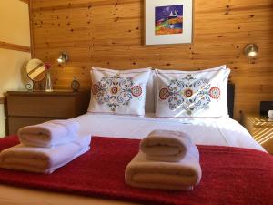 1 dormitorio con 1 cama con toallas en Rashfield Sheilings - Riverside Lodges, by Pucks Glen, Dunoon en Dunoon