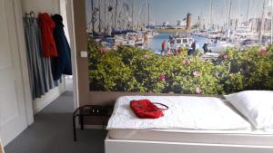 eine rote Handtasche auf einem Bett in einem Zimmer mit Yachthafen in der Unterkunft Marina 38-2 in Cuxhaven