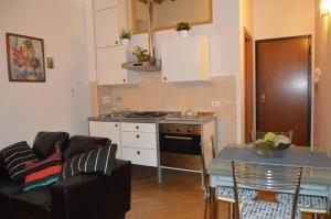 een keuken en een woonkamer met een bank en een tafel bij Appartamento La Maddalene in Pisa