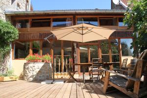 ein Regenschirm auf einem Deck vor einem Haus in der Unterkunft VALRELEY, chambres et table d'hôtes eco-friendly avec bain nordique au sud du massif du Jura in Champagne-en-Valromey