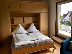 Bett in einem Zimmer mit Fenster in der Unterkunft FeWo Piper in Grömitz