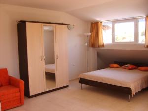 ソゾポルにあるGuest House Dimaのベッドルーム1室(ベッド1台、鏡、椅子付)