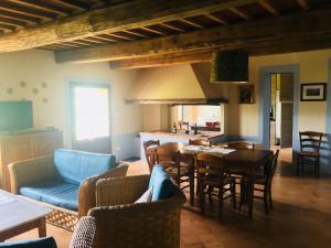 a living room with a table and chairs and a kitchen at Godiolo in Montepulciano