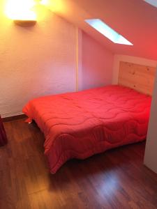 sypialnia z czerwonym łóżkiem w pokoju w obiekcie Loc luz st sauveur 1 w mieście Luz-Saint-Sauveur