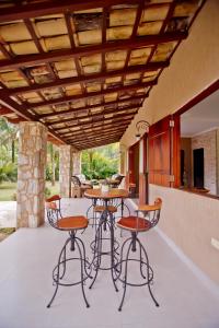 a patio with a table and chairs and a kitchen at Vila Noah Pousada in Paraty