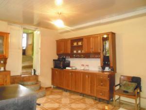 a kitchen with wooden cabinets and a counter top at Jimsher Naveriani Guesthouse in Zhabeshi