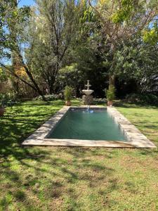 a small swimming pool with a fountain in a yard at The Lemon Tree in Prince Albert