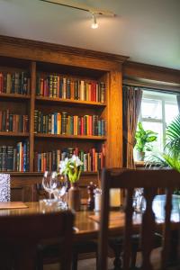 a dining room with a table and book shelves with books at Arrow Mill- Brunning and Price in Alcester