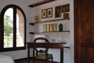 a room with a desk with a chair and a window at La Casa dei Vezzi in San Gimignano