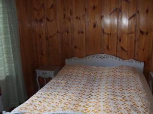 um quarto com uma cama e uma parede de madeira em Holiday Home Raanumaja ii by Interhome em Lampsijärvi