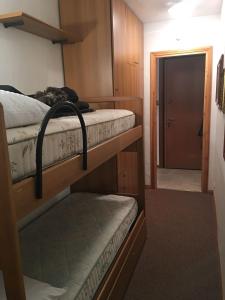 Zimmer mit 2 Etagenbetten und einer Tür in der Unterkunft Paradiso delle Nevi in Sestriere