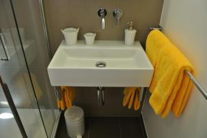 ein Badezimmer mit einem weißen Waschbecken und einer Dusche in der Unterkunft Gasthaus Tübli Gersau in Gersau
