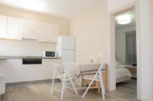 eine Küche und ein Esszimmer mit einem Tisch und Stühlen in der Unterkunft Apartamentos El Marinero - Caletilla in Caleta de Sebo
