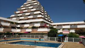 a building with a swimming pool in front of a building at Studio vue panoramique-centre ville in La Grande-Motte +15 photos