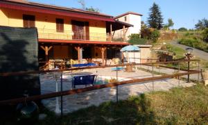 a house with a swimming pool in front of a house at AGRITURISMO NIZUR'IN in Roccaverano