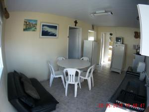 cocina y comedor con mesa y sillas en Casa na Praia da Pinheira, en Palhoça