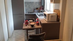 - une petite cuisine avec une petite table et un four micro-ondes dans l'établissement L'Oustalet, à Carbonne