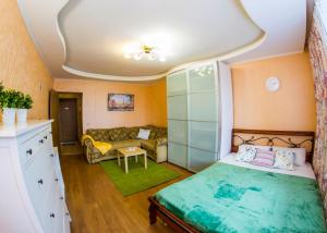 オムスクにあるRENT-сервис Apartments on Mayakovskogo 20のベッドルーム(ベッド1台、ソファ付)