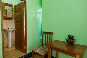 a room with a table and a chair and a sink at River Park Inn in San Ignacio