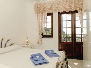 ein Schlafzimmer mit einem Bett und einem Fenster mit Handtüchern darauf in der Unterkunft Apartment Duplex Loureiro by Interhome in Ericeira